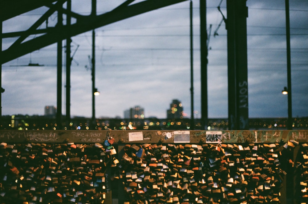 a bunch of padlocks on a bridge with a city in the background