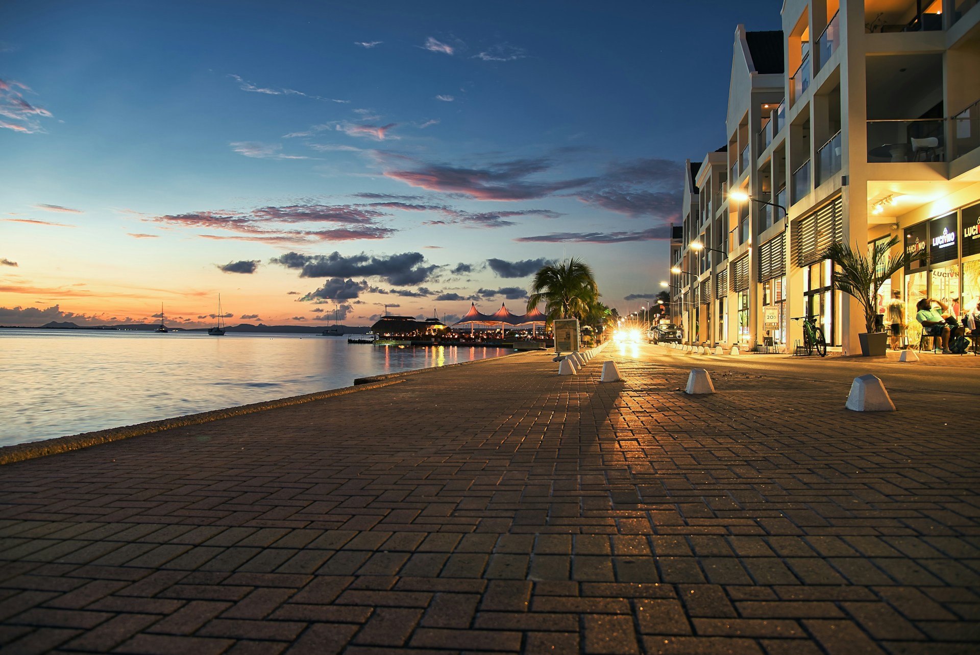 a street lined with tables next to a body of water