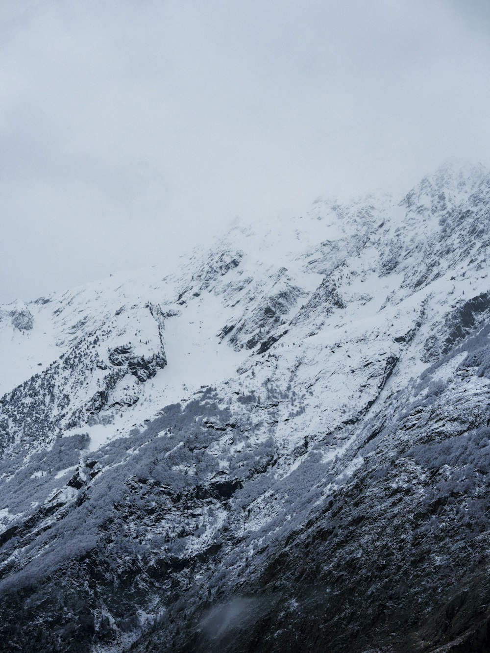 a mountain covered in snow with a sky background