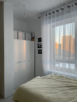 A bright bedroom with minimalist decor and soft textures creating a peaceful retreat.