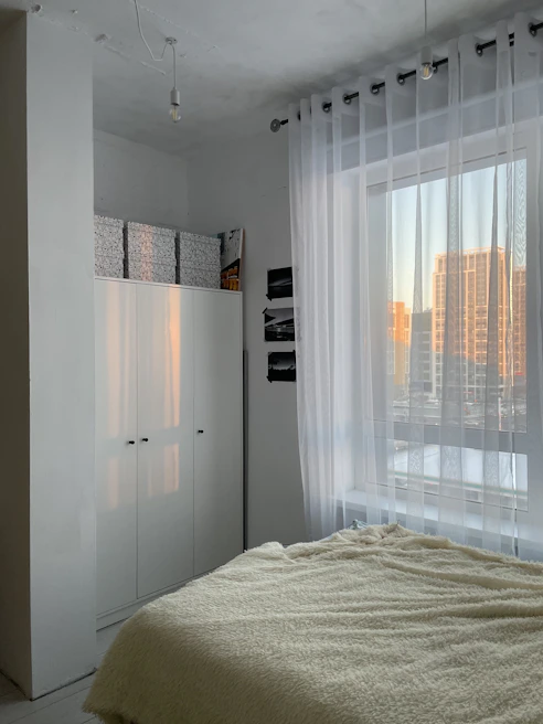 Cozy bedroom with minimalist decor and soft bedding, perfect for rest