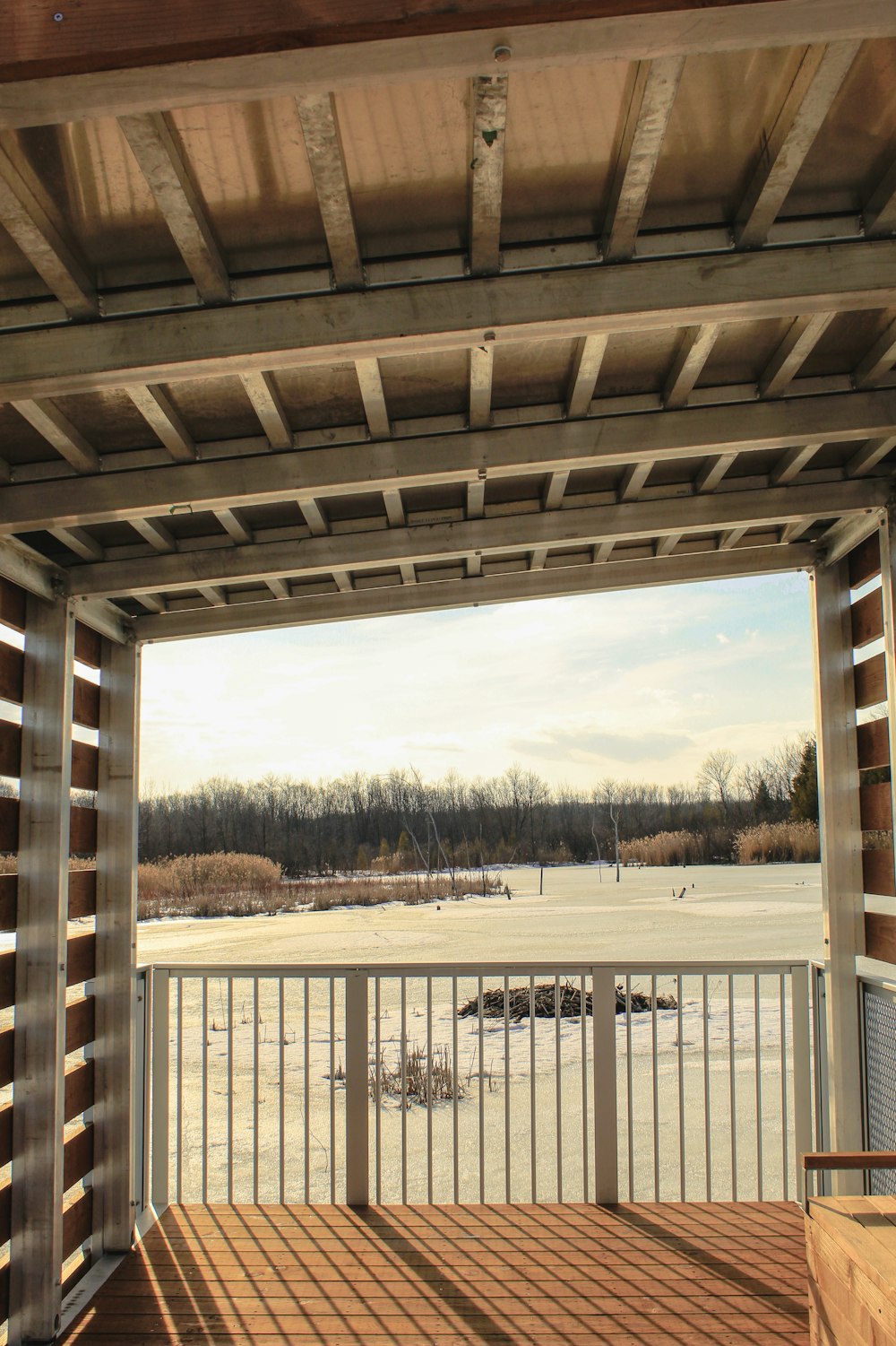 a view of a snowy field from a covered porch