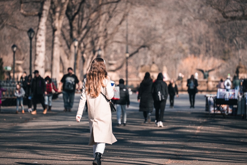 a woman walking down a street next to a bunch of people