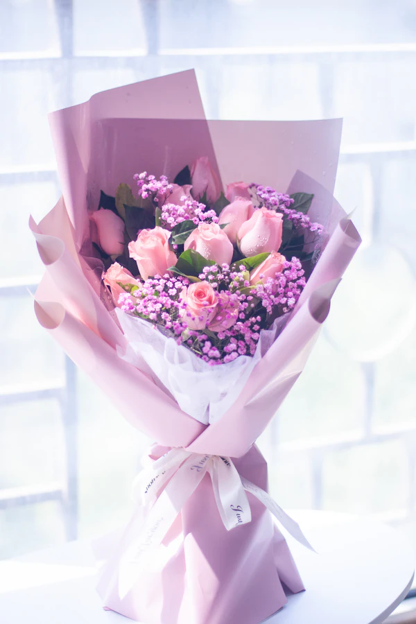 Pink roses and lilac flowers wrapped in pink paper
