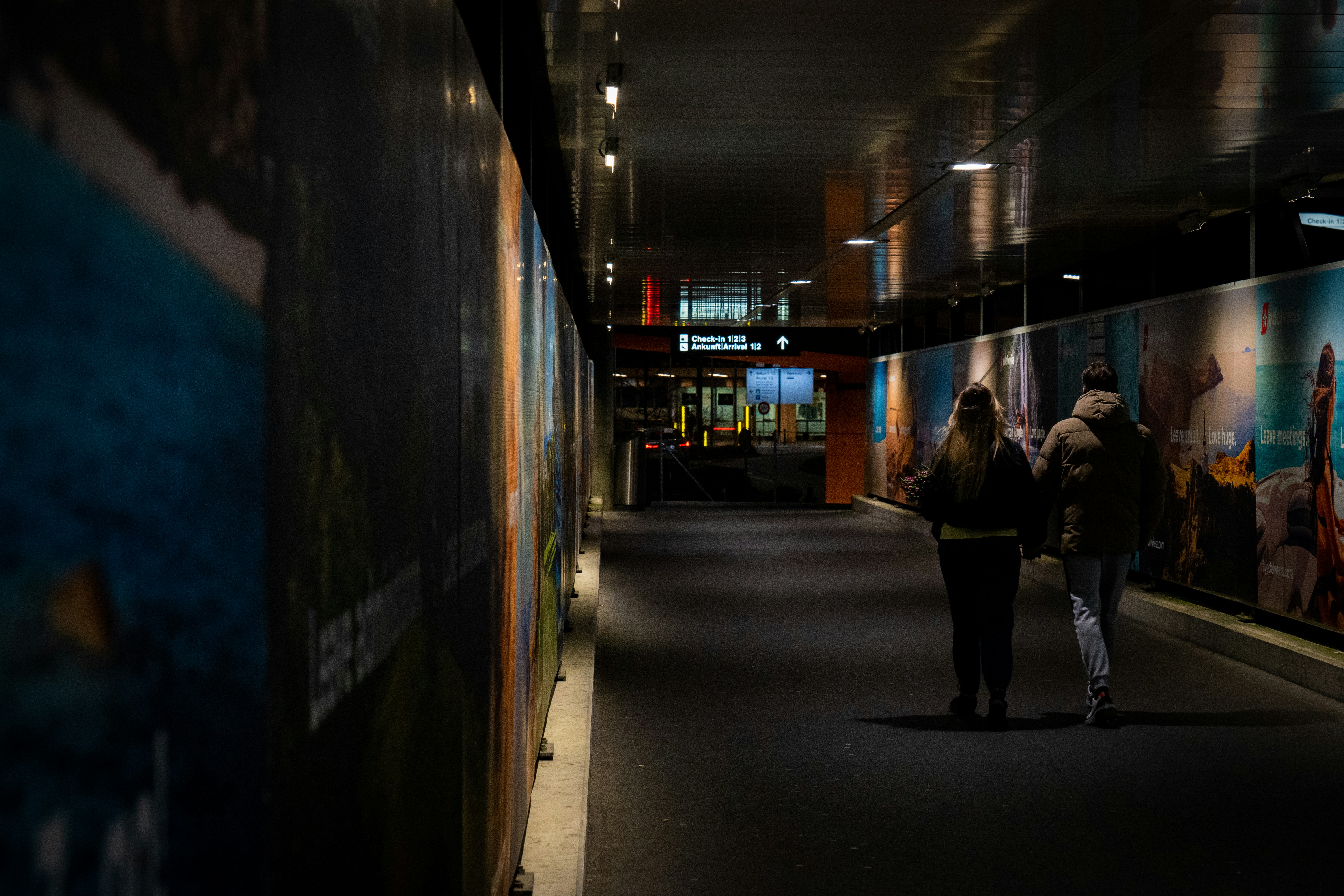 a couple of people that are walking down a hallway