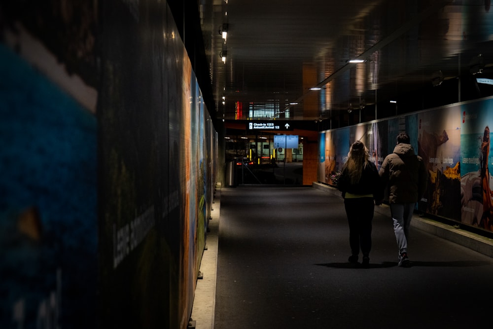 a couple of people that are walking down a hallway