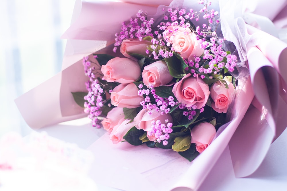 a bouquet of pink roses wrapped in pink paper