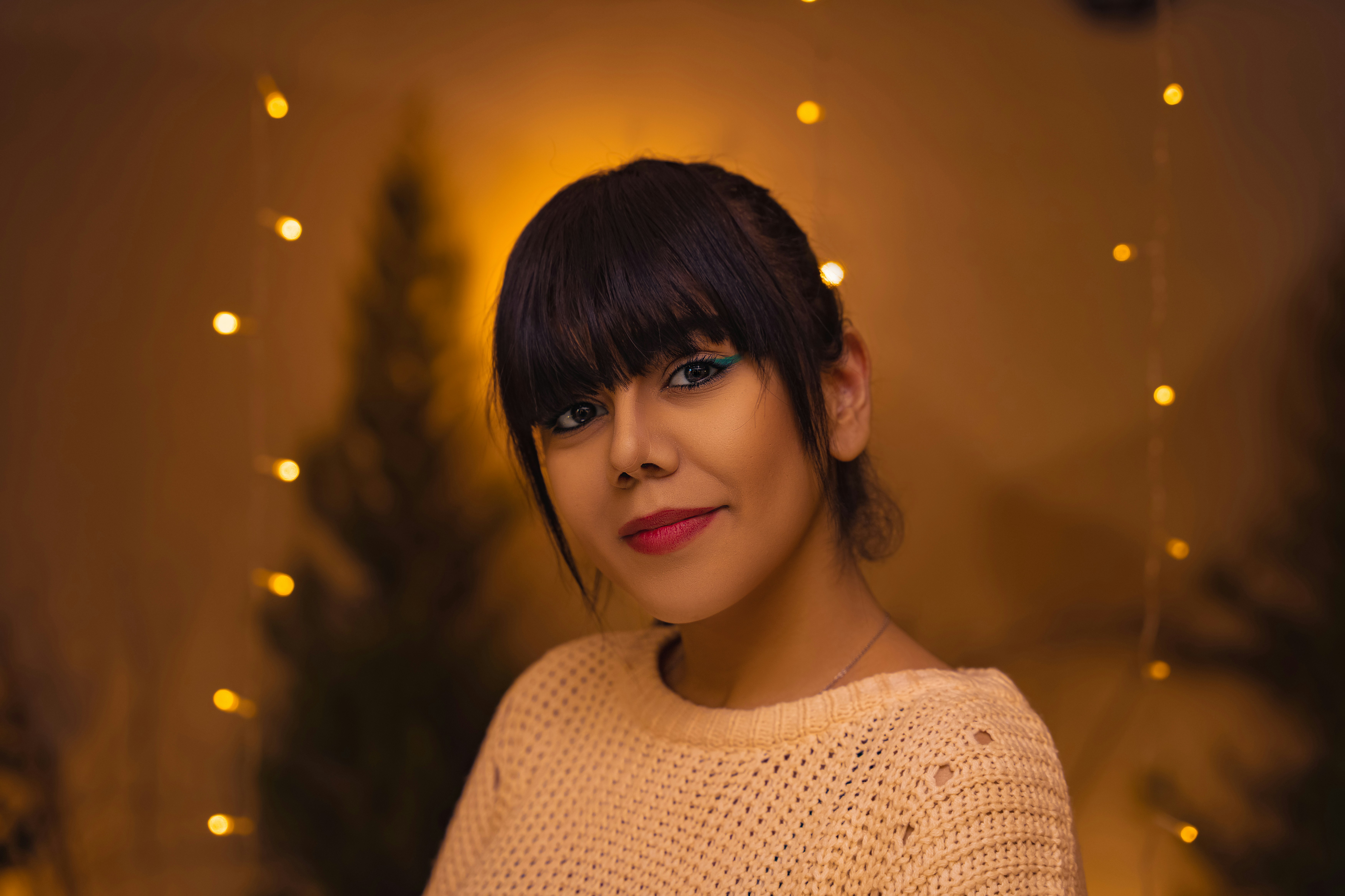 Young woman with soft natural light, dreamy blurred background in warm cream and rose tones, intimate portrait photography