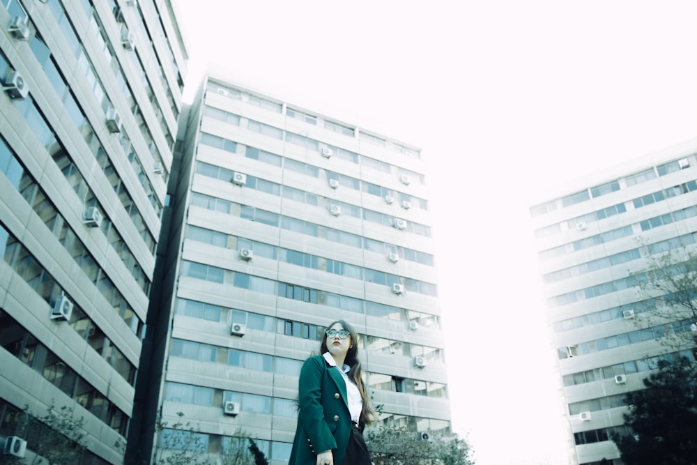 a woman standing in front of a tall building