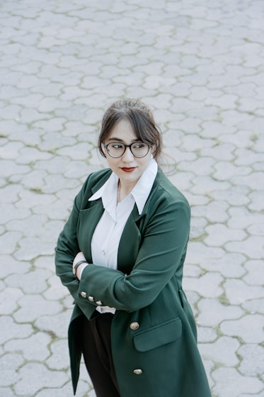 a woman wearing glasses and a green coat
