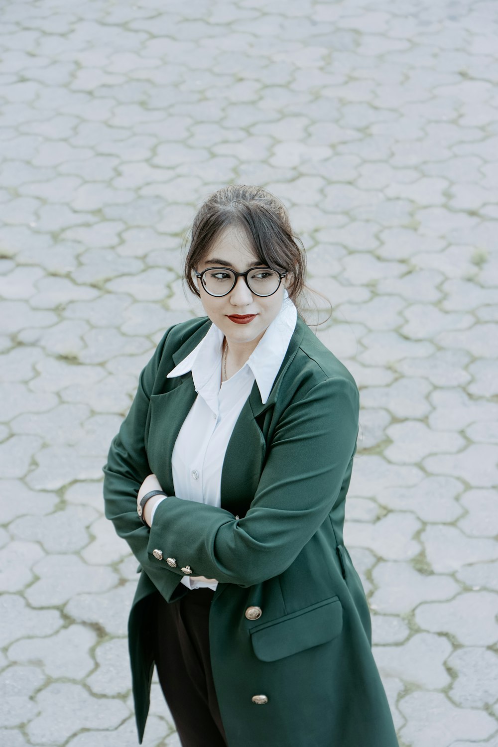 a woman wearing glasses and a green coat