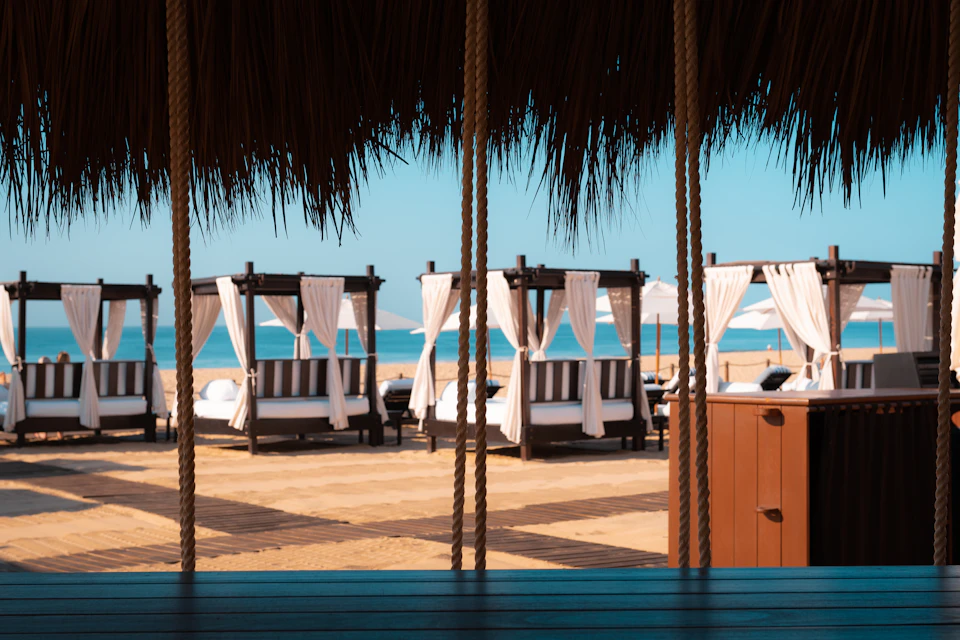 Serene beachfront resort with lounge chairs and umbrellas on sandy shore facing azure ocean