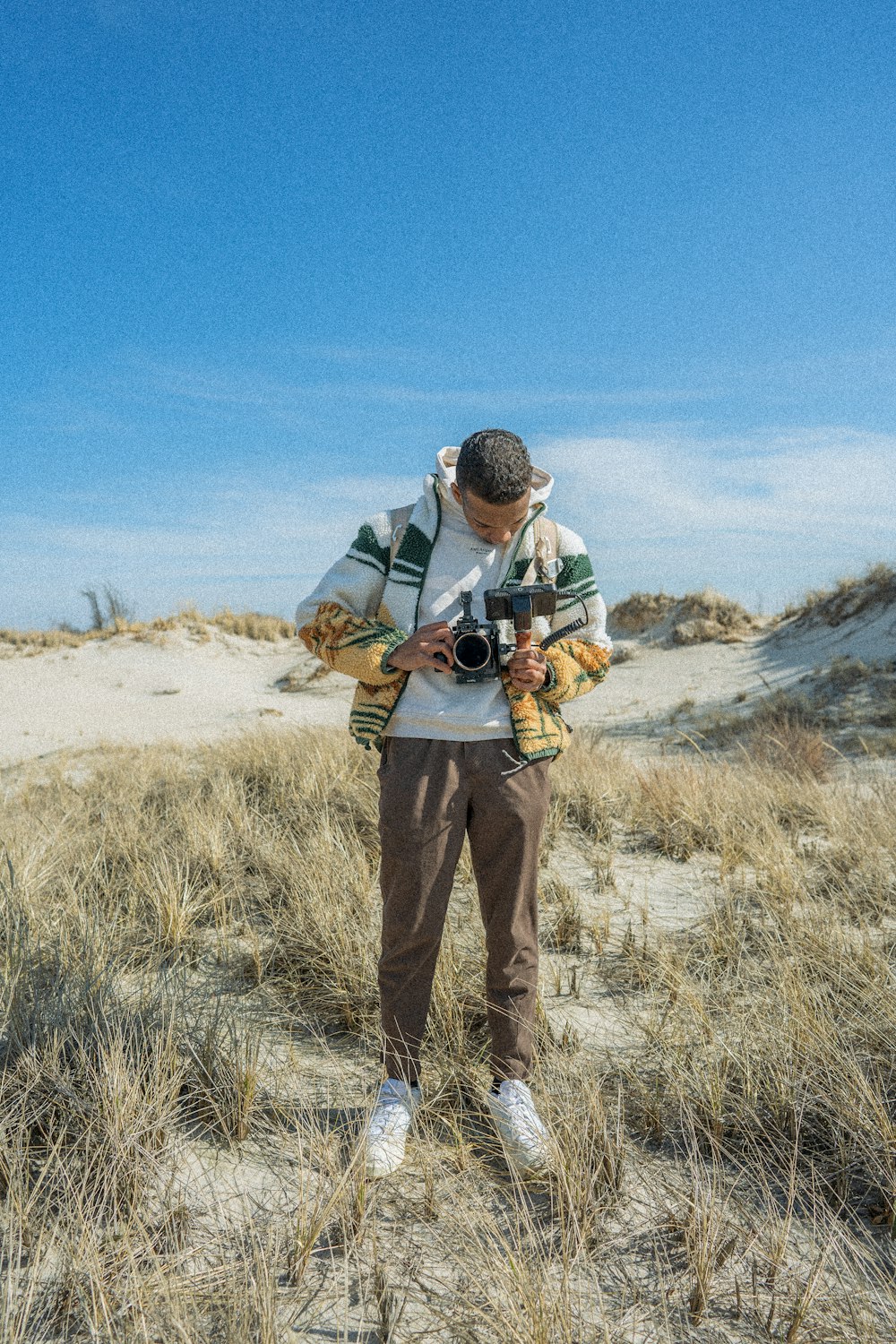 um homem de pé em um campo com uma câmera