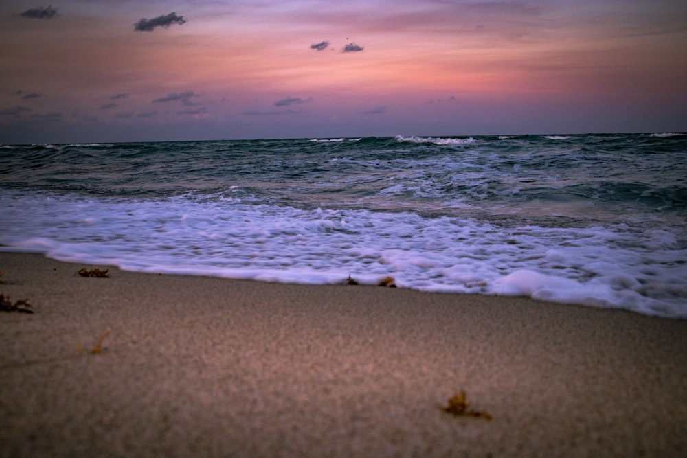 a sandy beach with waves coming in to shore