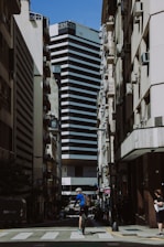 a man riding a bike down a street next to tall buildings