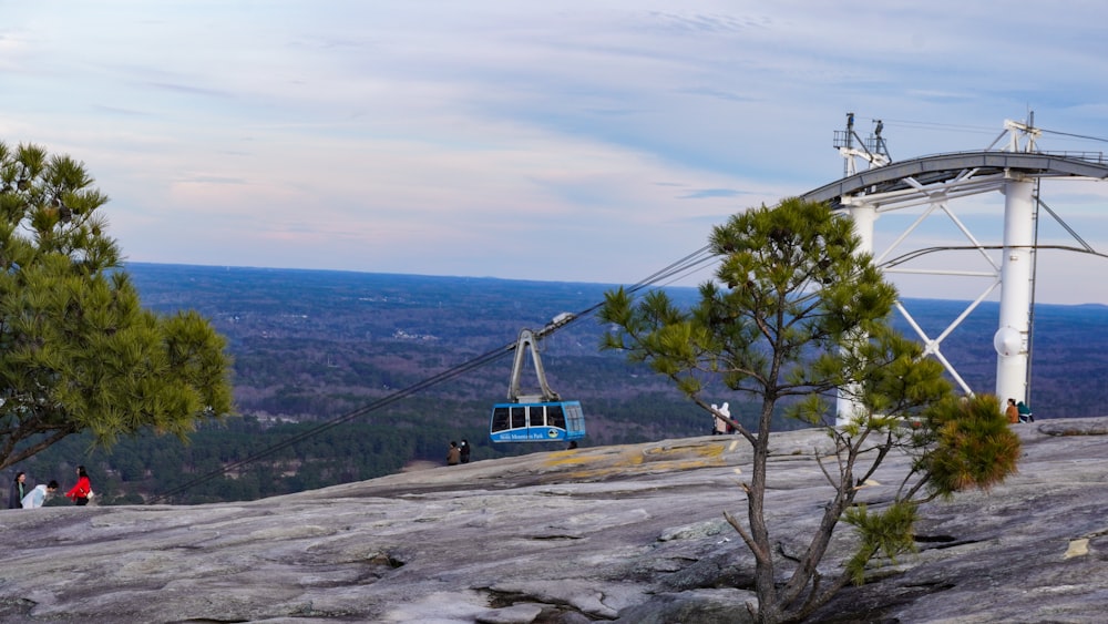 um teleférico azul e branco sentado no topo de uma montanha