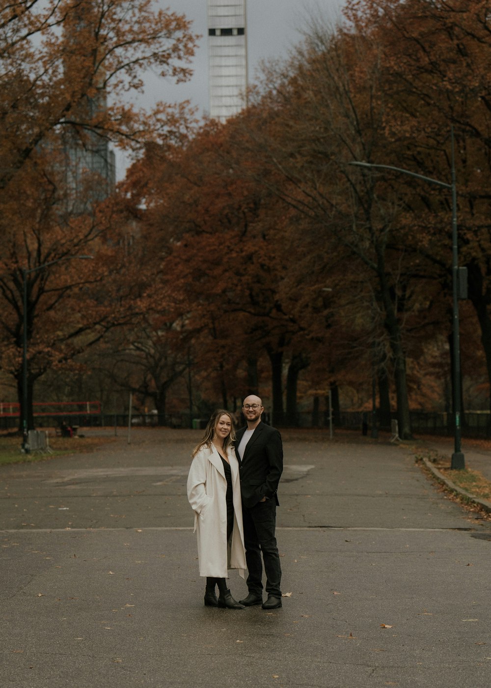 a man and a woman standing in the middle of a road