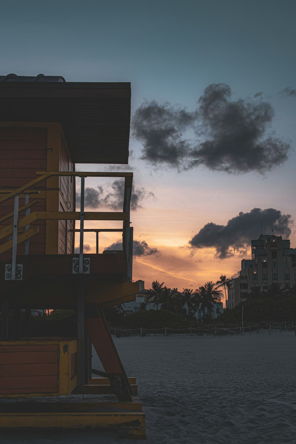 a lifeguard tower on the beach at sunset