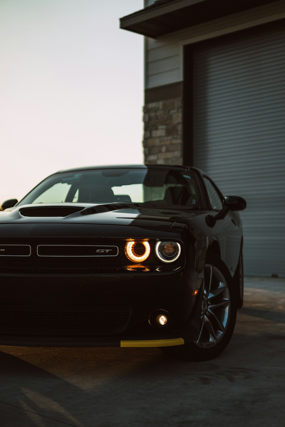 a black car parked in front of a garage