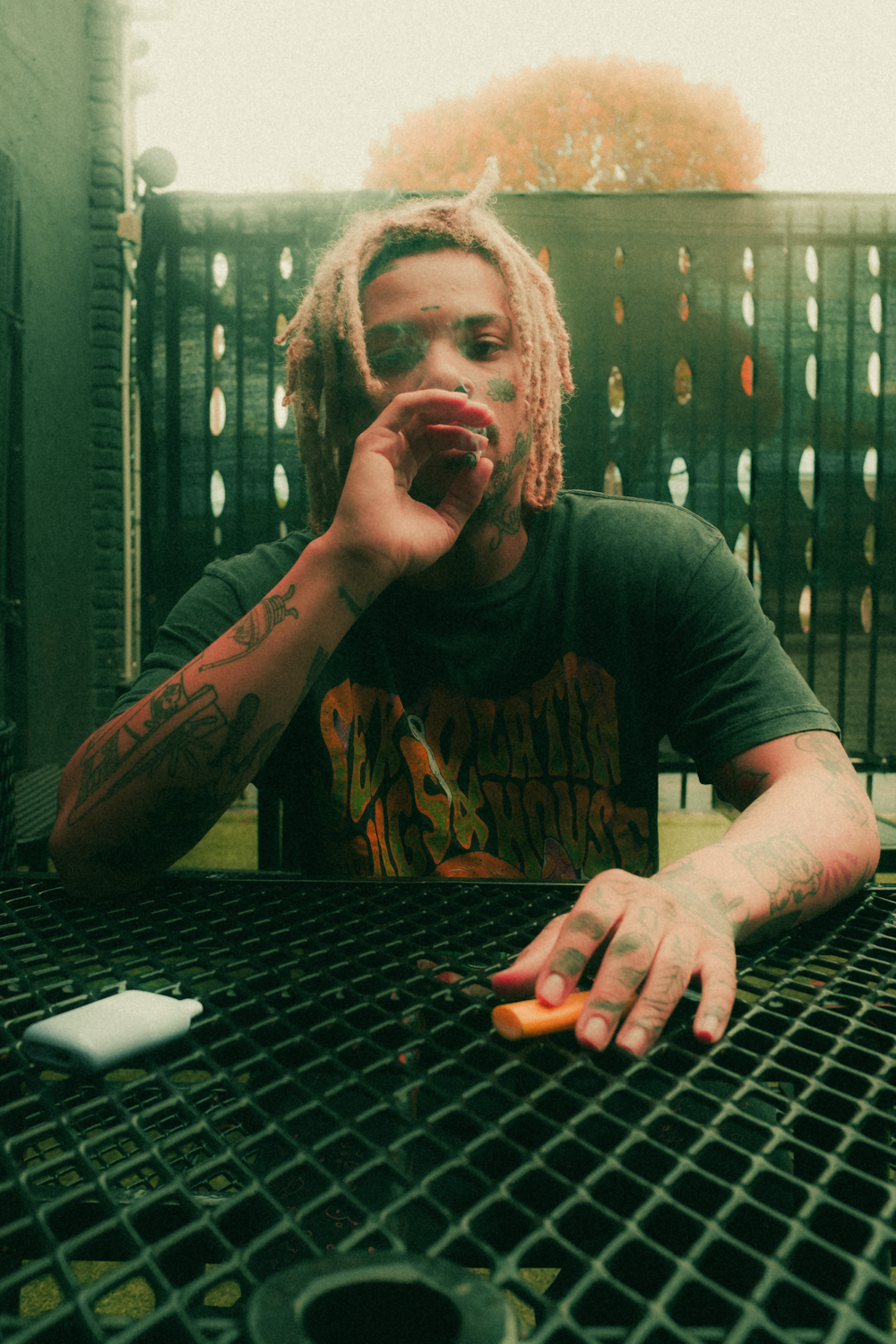 a man with dreadlocks sitting at a table