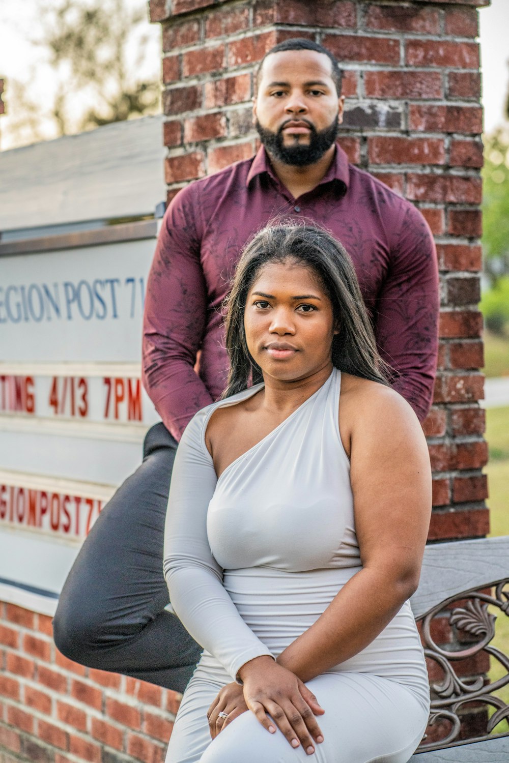 a woman sitting on a bench next to a man