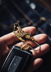 Close-up of hands holding keys with a modern residential building in the background.