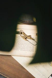 A regal crown resting atop a weathered ancient manuscript illuminated by soft candlelight.