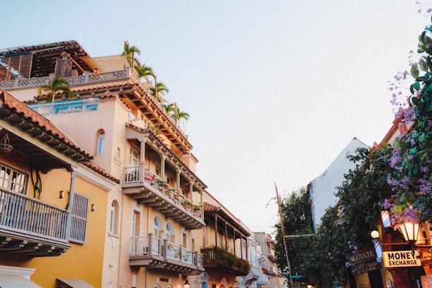 A vibrant collage showing supermarket aisles, retail shops, a real estate building, and currency exchange counters.
