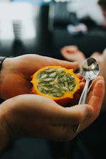 Close-up of hands holding fresh exotic fruits symbolizing agricultural value.