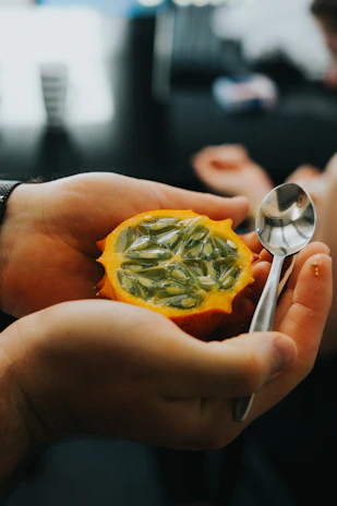 Close-up of hands holding fresh exotic fruits symbolizing agricultural value.