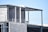 An unfinished building under construction with visible concrete blocks and steel beams. The structure appears to be at an early stage with some parts exposed and not yet completed. There are electrical conduits and reinforcement rods visible.