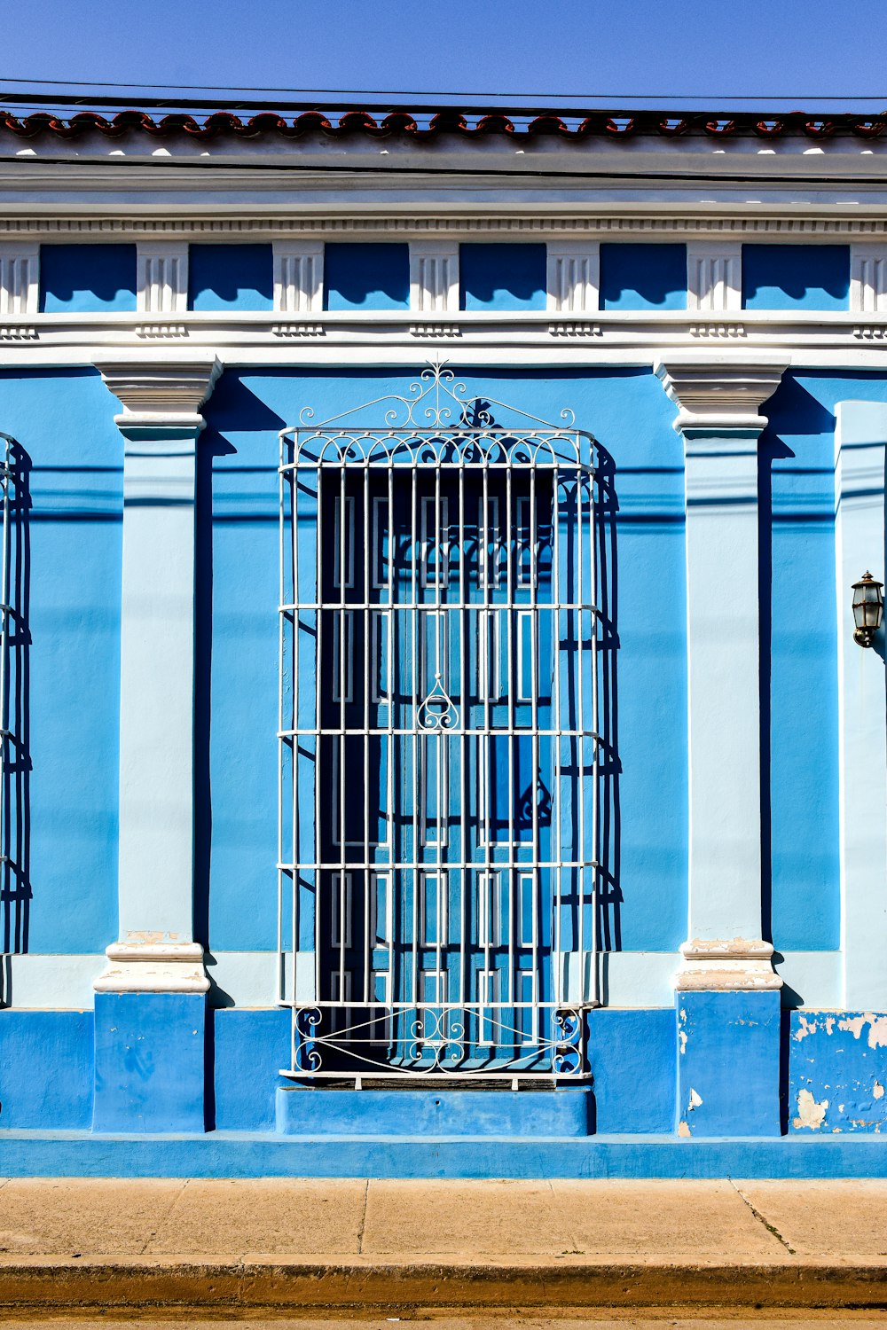 un edificio azul con una jaula en la parte delantera