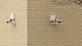 CCTV cameras installed on a building corner overlooking a street.