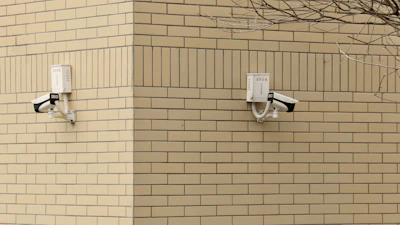 CCTV cameras installed on a building corner overlooking a street.