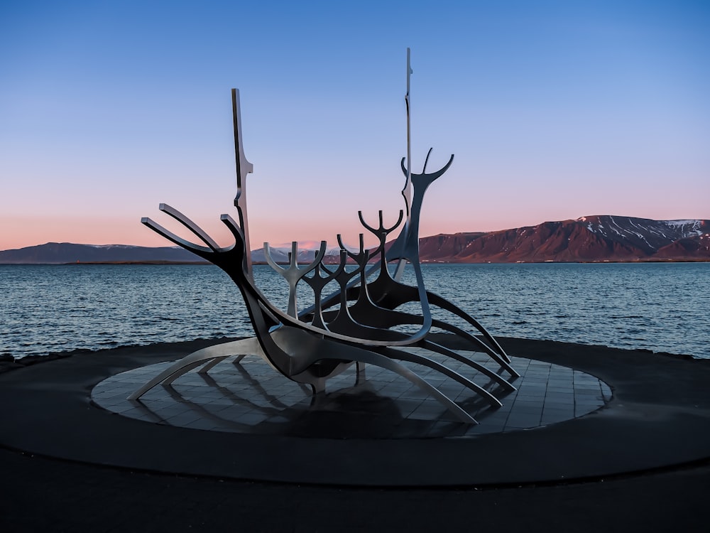 uma escultura de metal de um barco em um corpo de água