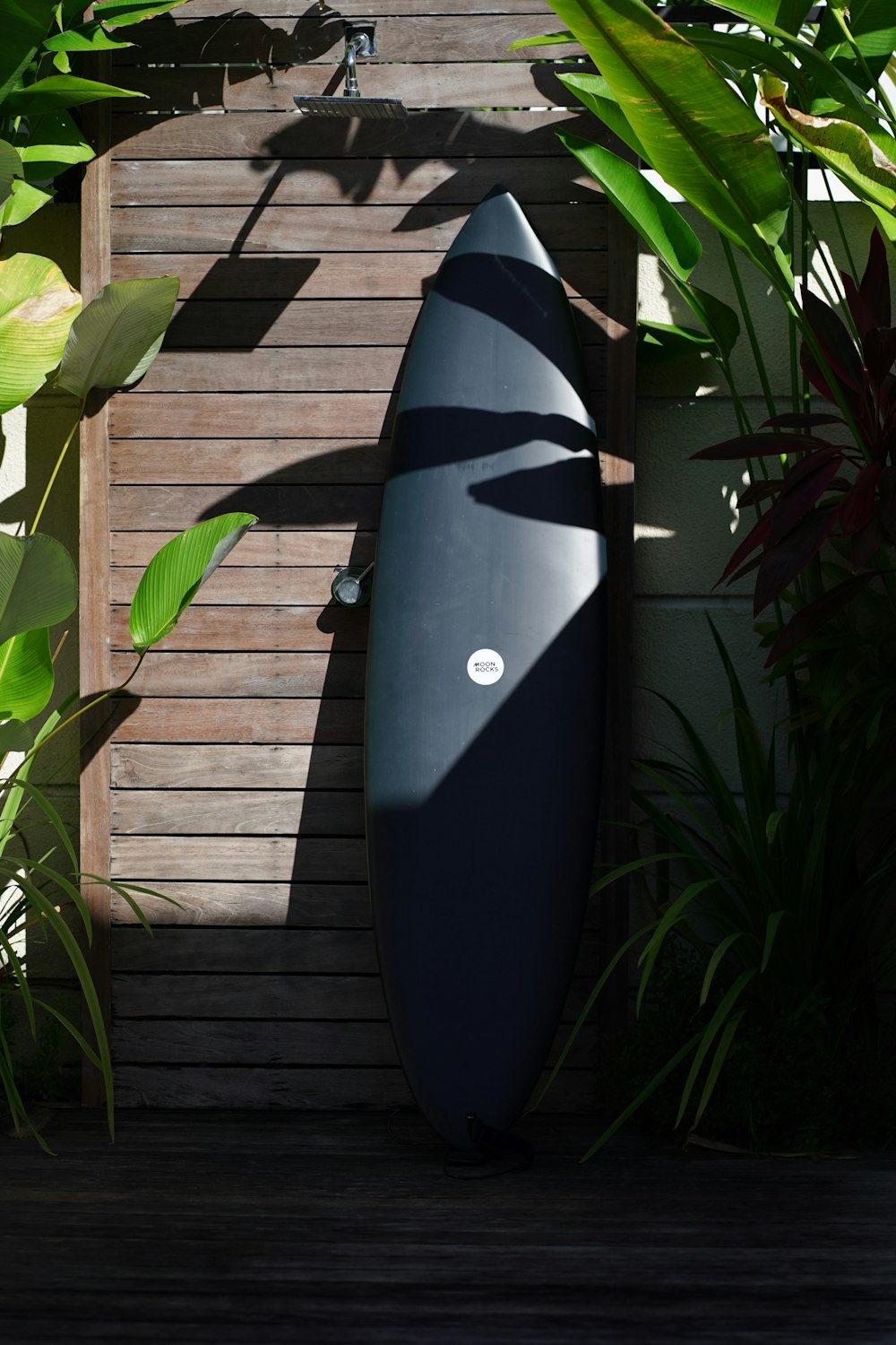 a blue surfboard leaning against a wooden wall
