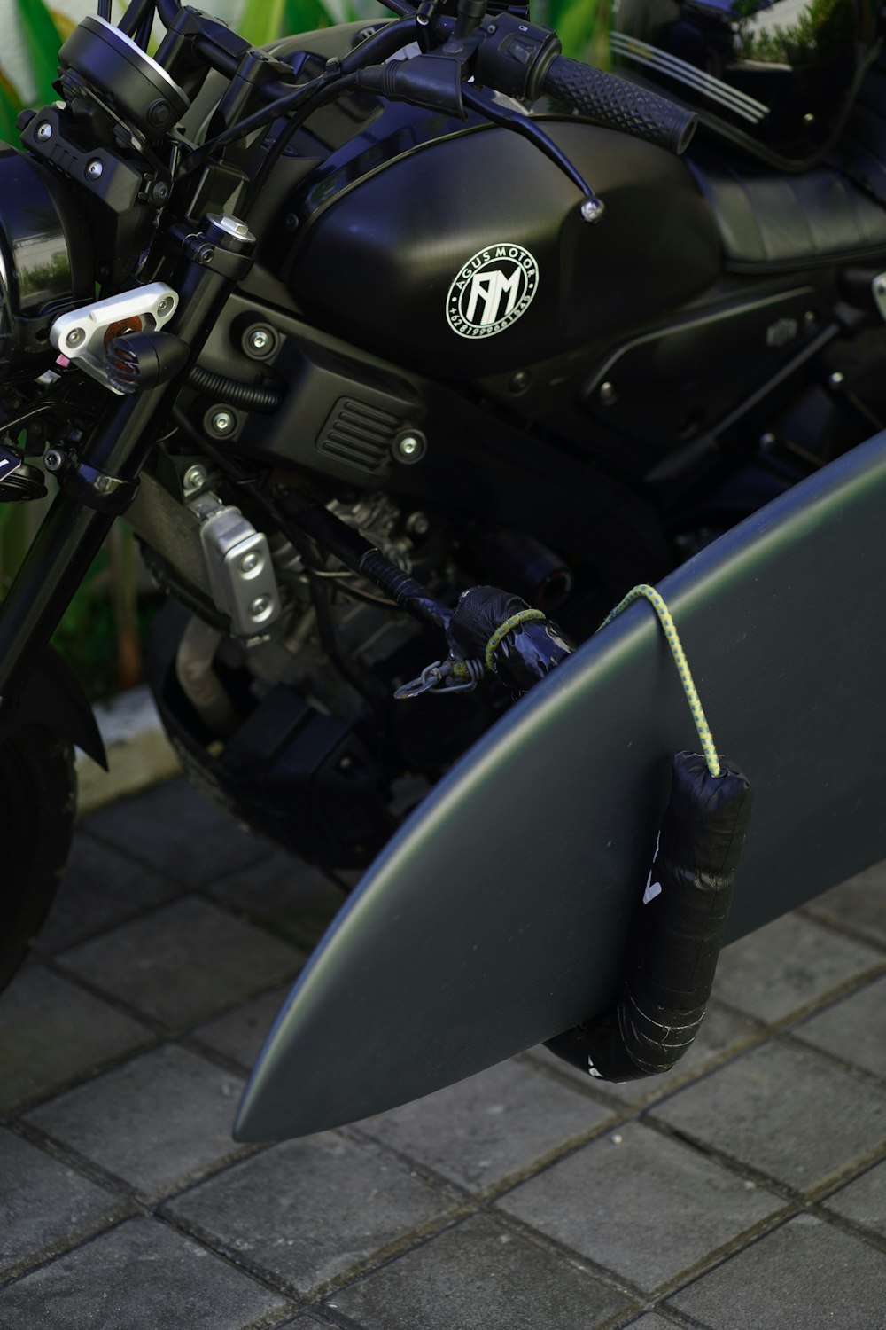 a black motorcycle with a surfboard attached to it