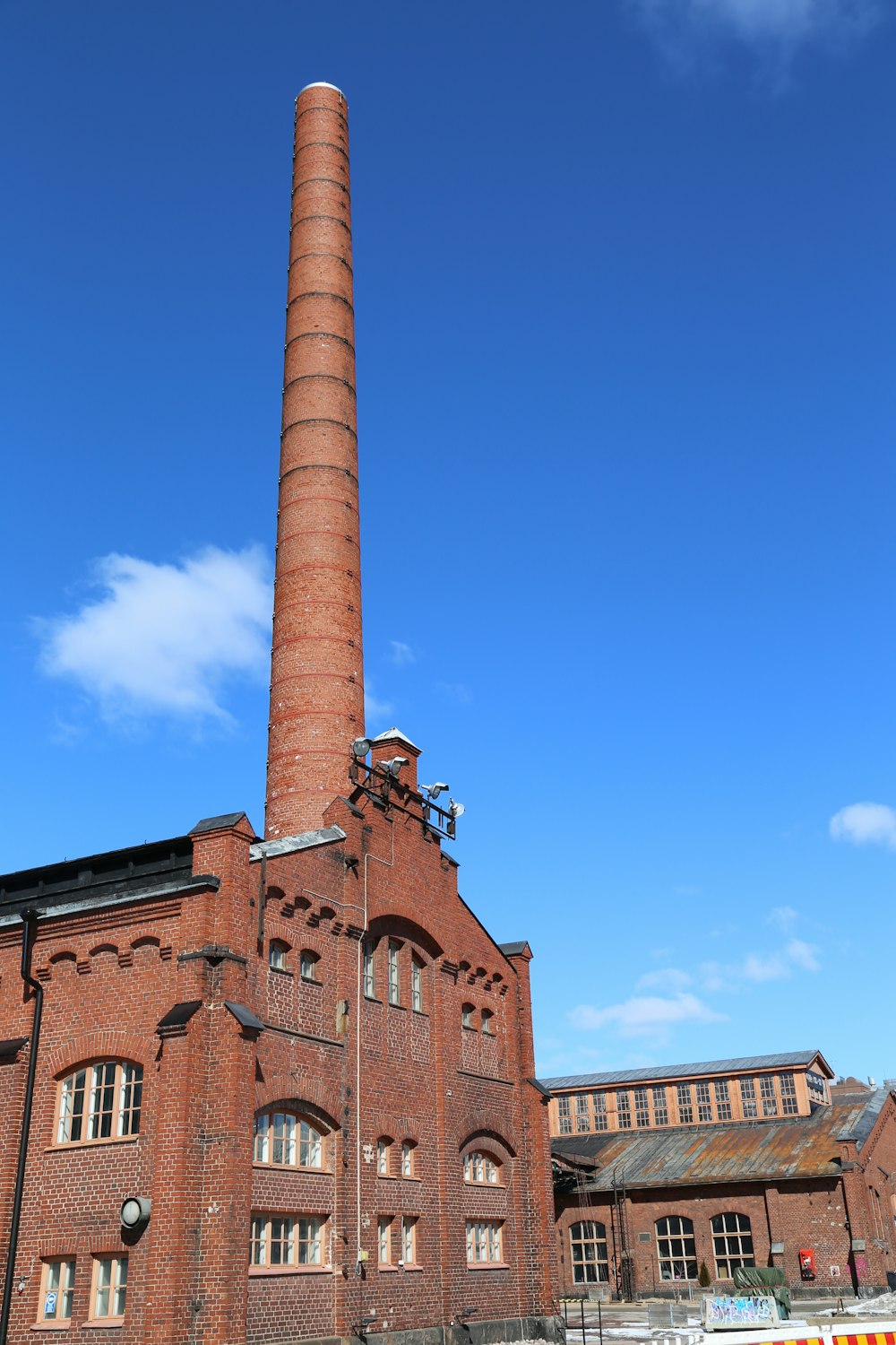 a large brick building with a tall chimney