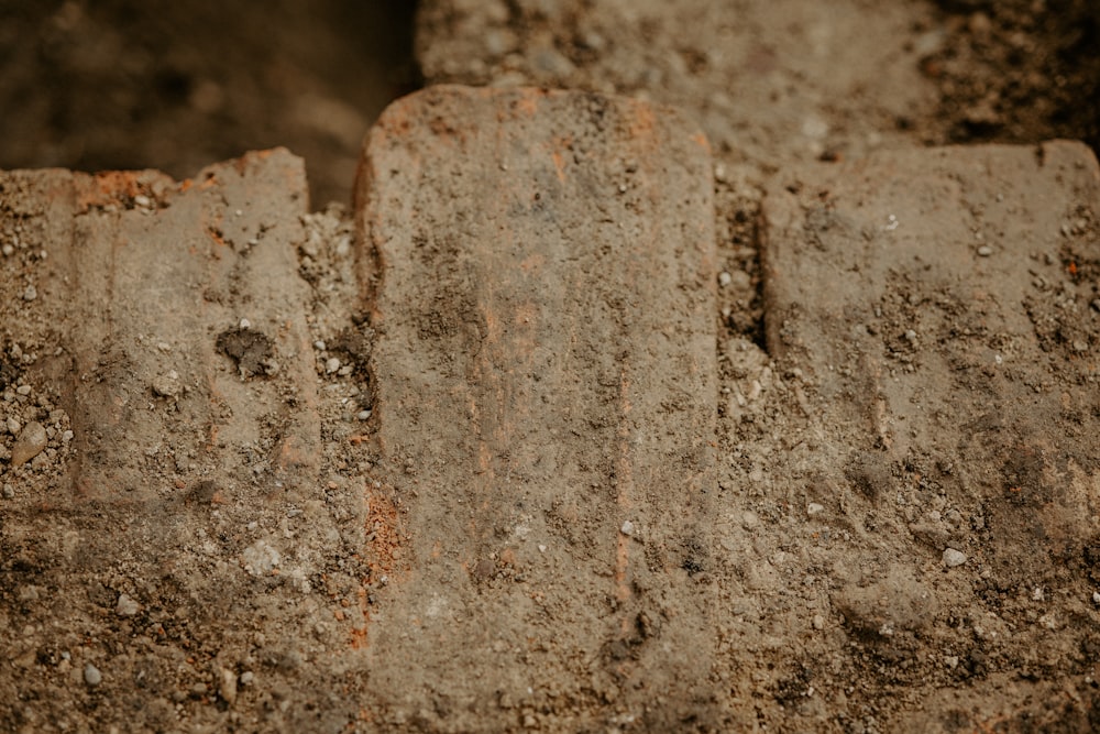 a close up of a brick wall with dirt on it