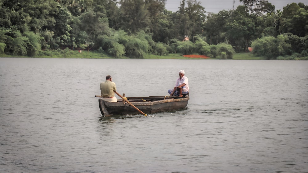 two people in a row boat on a lake