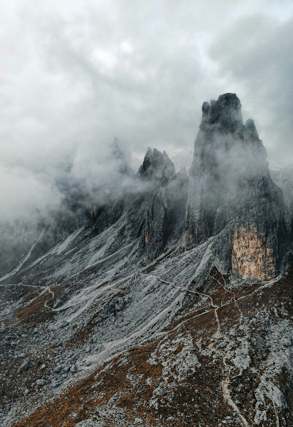 a mountain covered in snow and clouds on a cloudy day