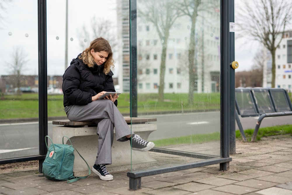 a woman sitting on a bench looking at her phone