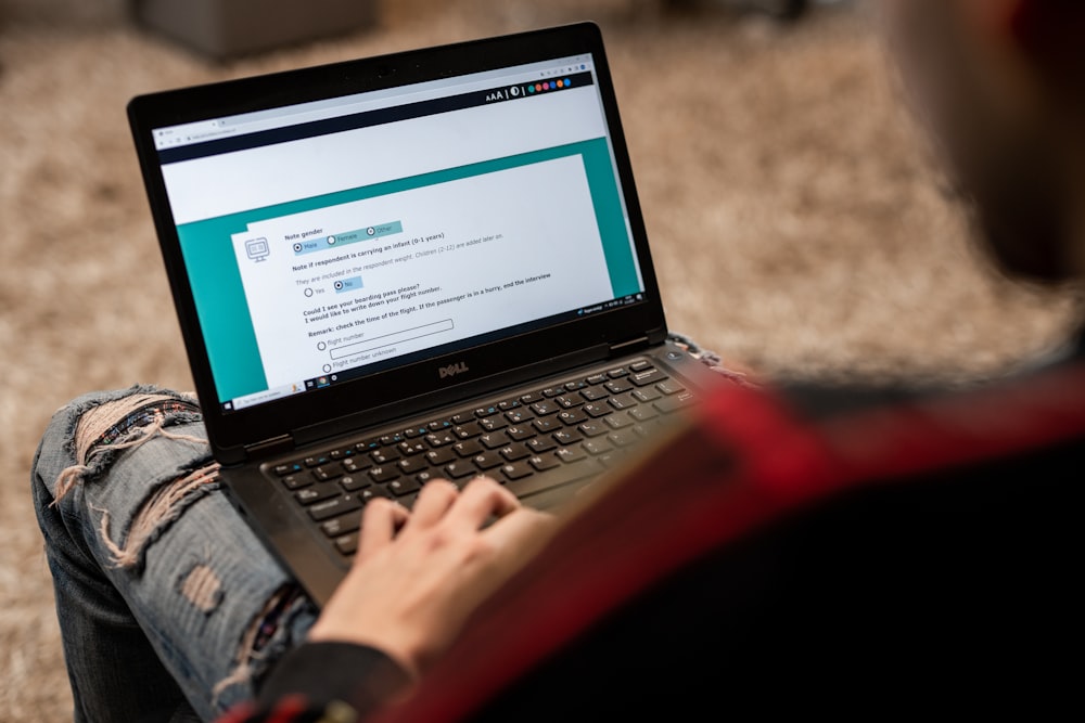 a person sitting on the floor using a laptop