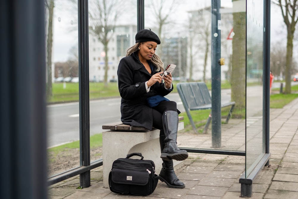 a woman sitting on a bench looking at her cell phone