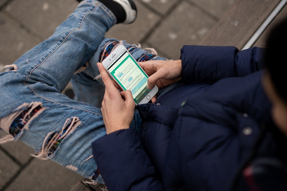 a person sitting on a bench using a cell phone