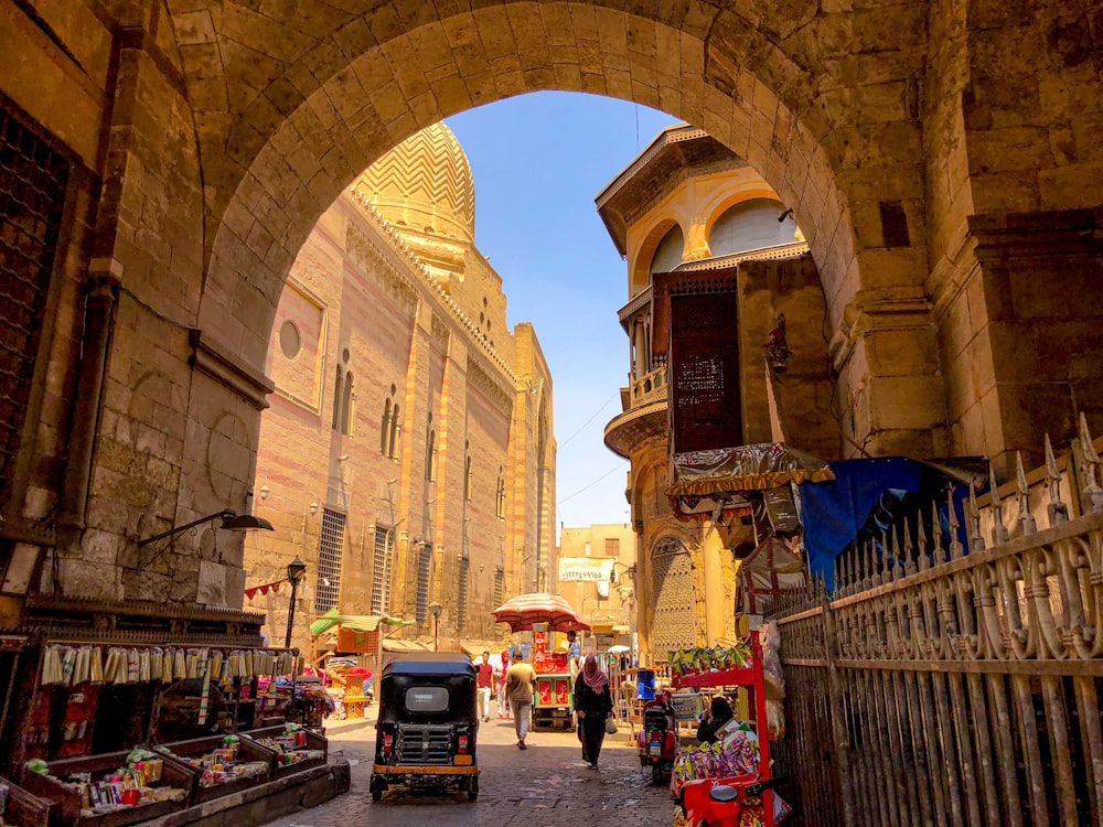 a narrow street with an archway leading to a market