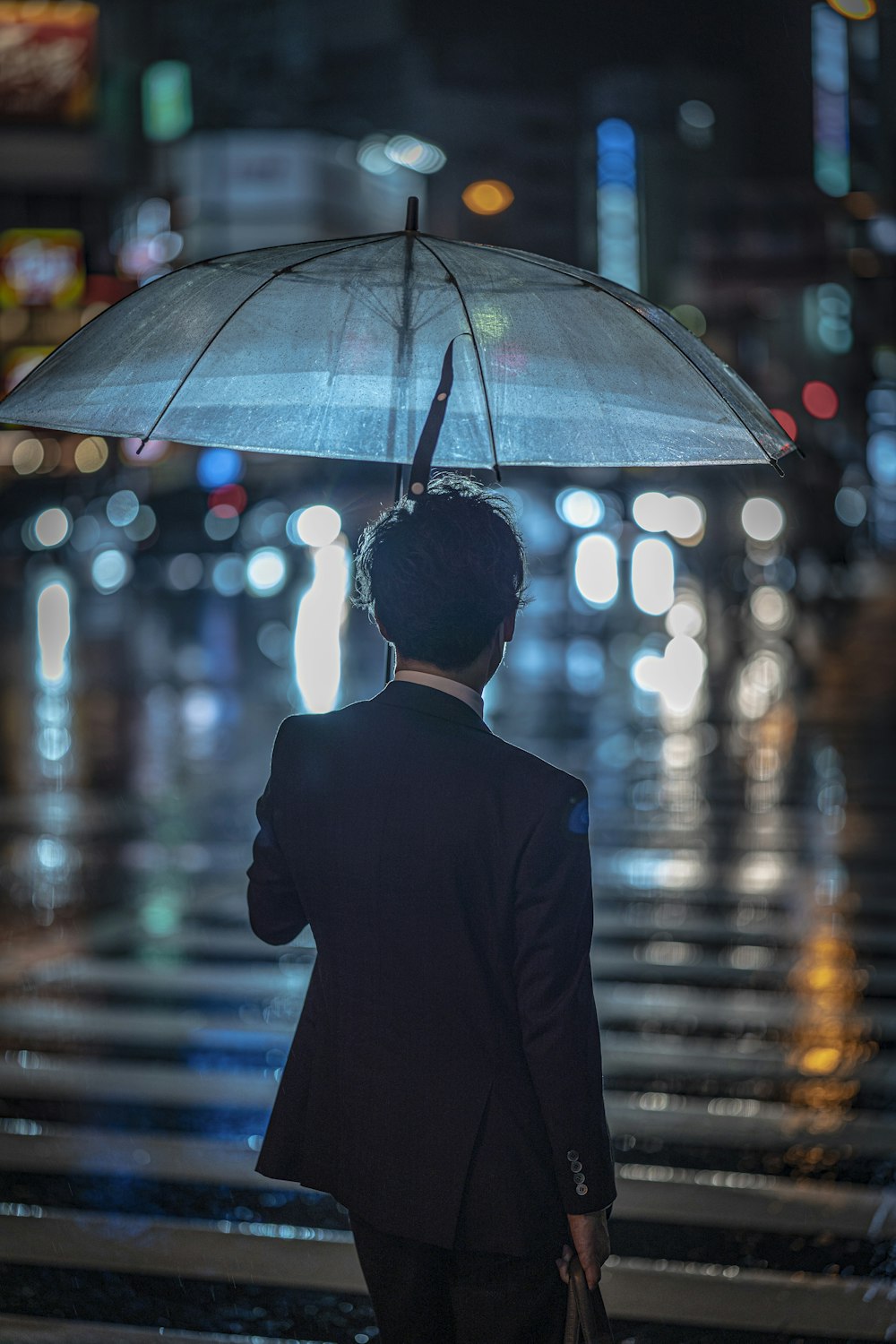 a man in a suit is holding an umbrella