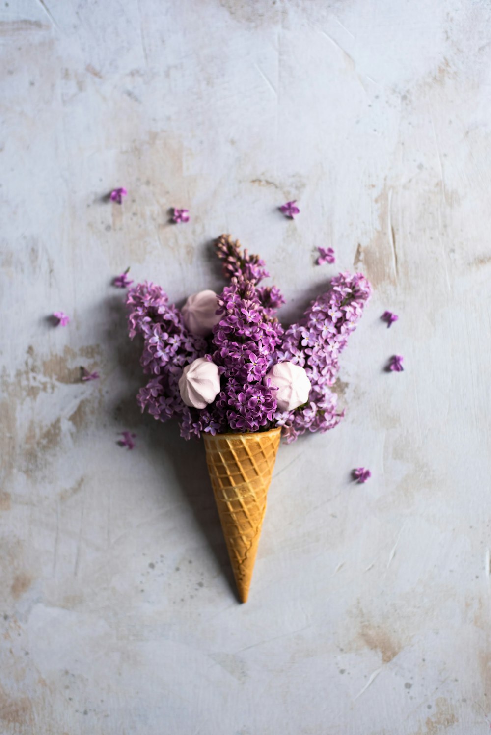 an ice cream cone filled with purple flowers