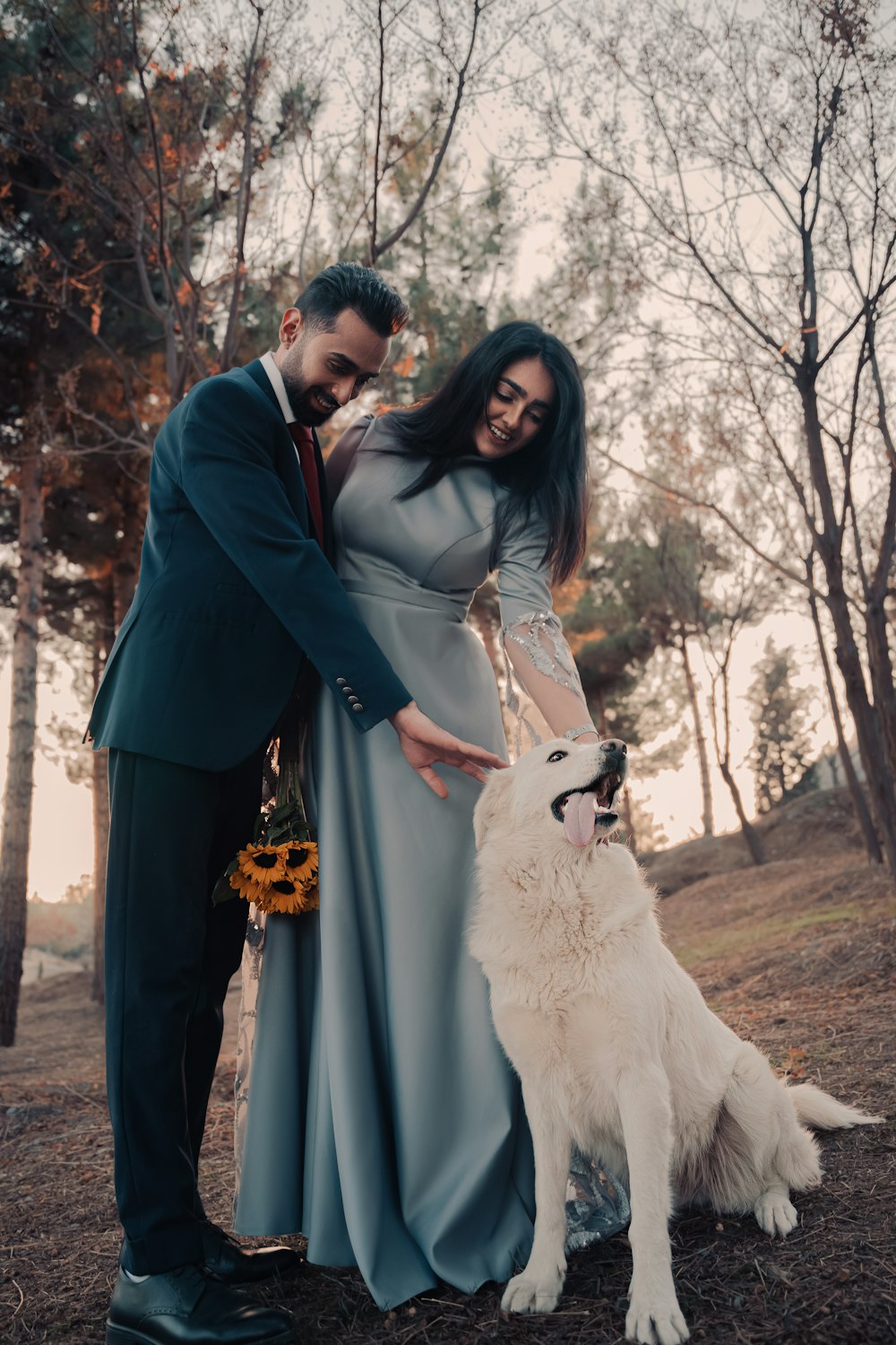 a man and woman standing next to a white dog