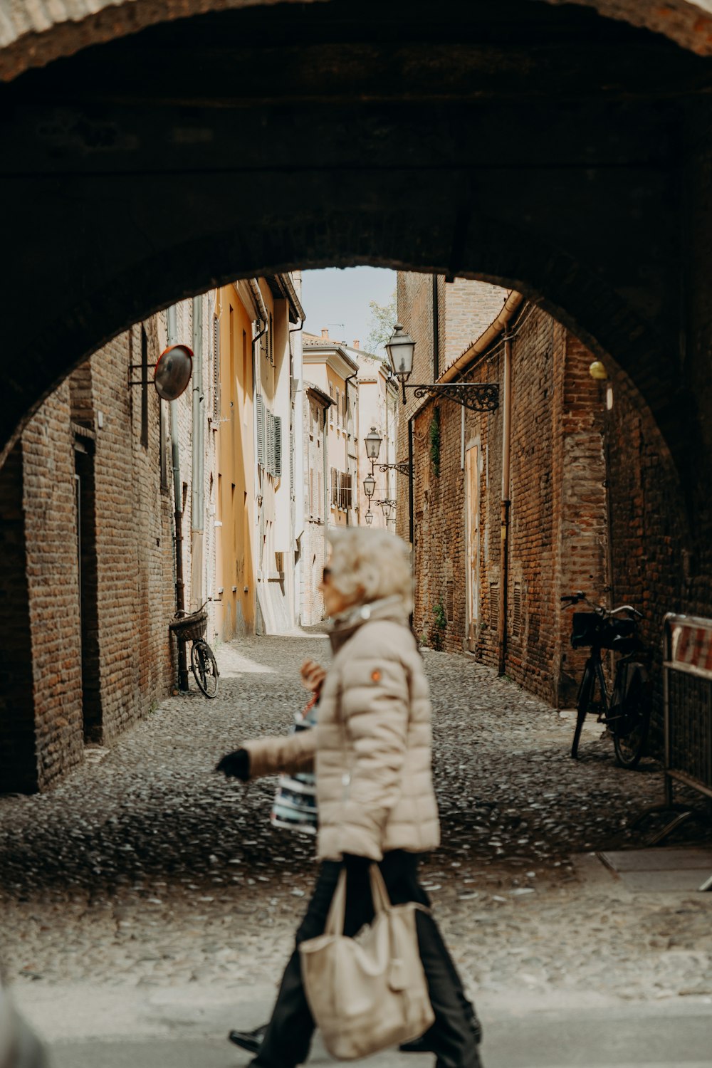 Eine Frau, die eine Straße unter einer Brücke hinuntergeht